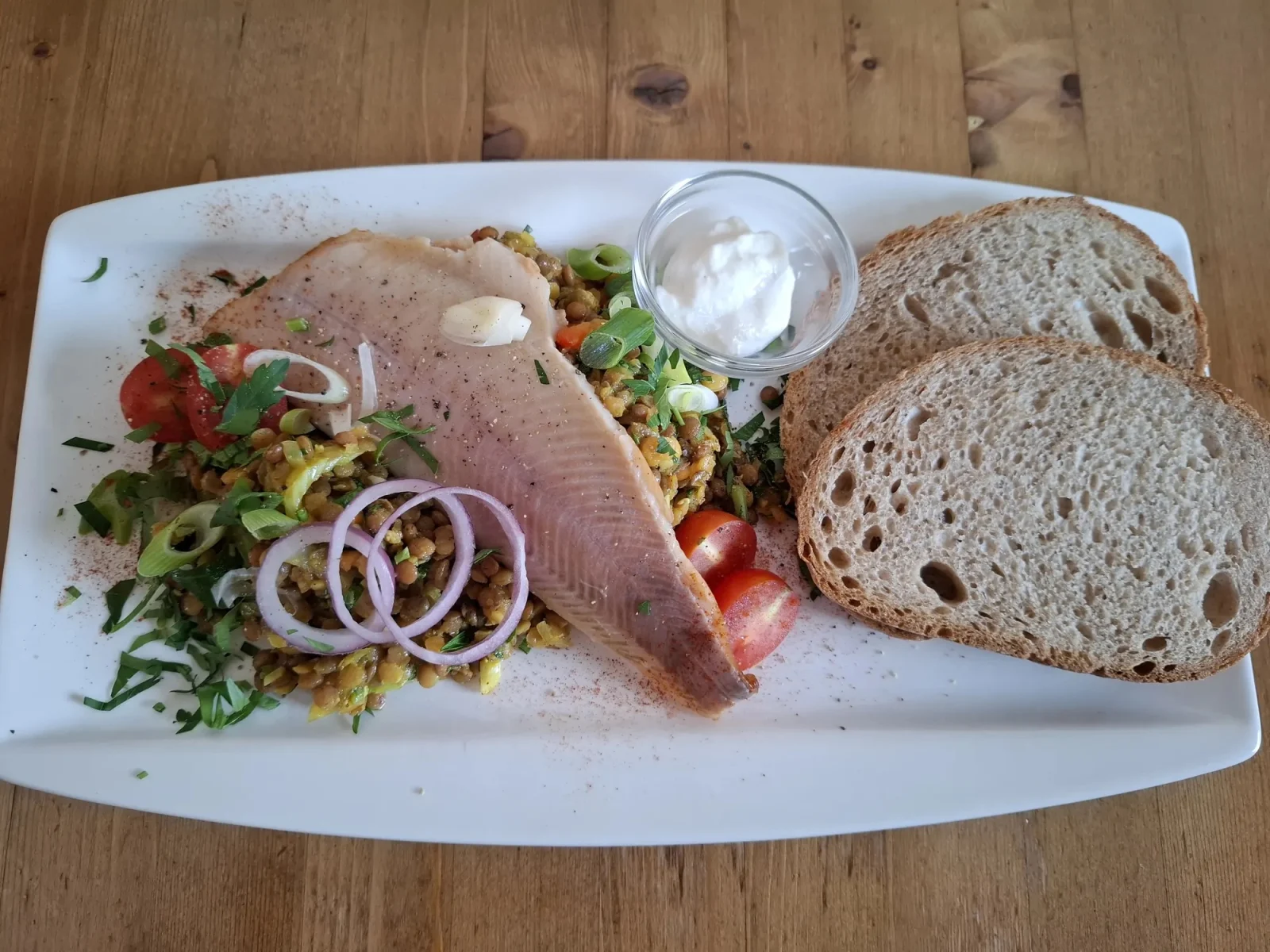 Geräuchertes Fischfilet auf Linsensalat mit Bauernbrot